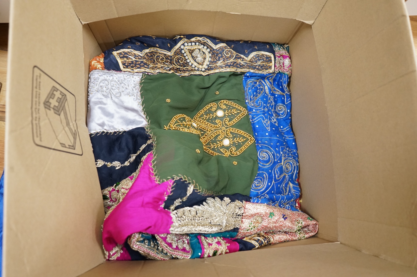 A quantity of mostly 20th century Middle Eastern and Indian woven and printed textiles and a peacock feather fan (2 boxes).